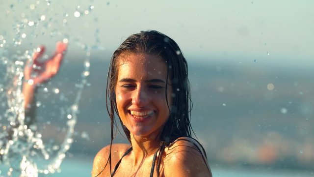Young woman being splashed with water 