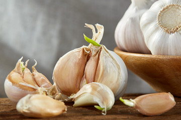 Garlic close up on wooden plate on rustic background, shallow depth of field, selective focus, macro