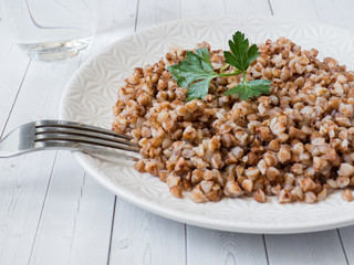 Buckwheat porridge with parsley leaves in a plate, healthy food