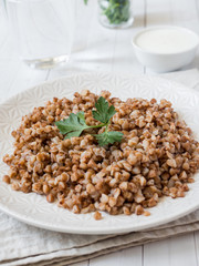 Buckwheat porridge with parsley leaves in a plate, healthy food