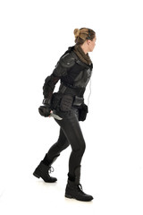 full length portrait of female  soldier wearing black  tactical armour, holding a remote knife, isolated on white studio background.