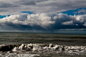 rain cloud over the stormy sea on a sunny day.