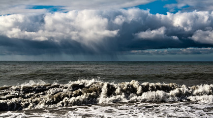 rain cloud over the stormy sea on a sunny day.