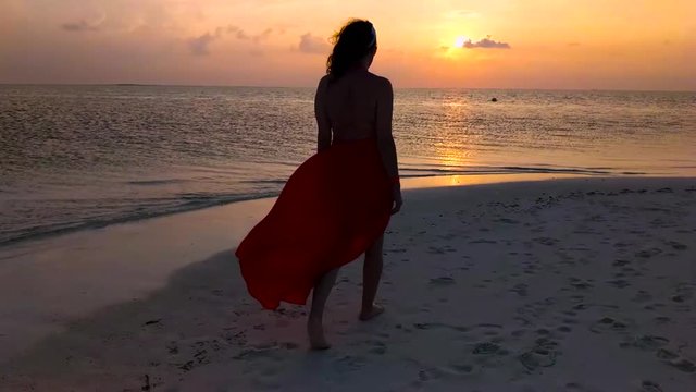 Girl Woman Walking on the Beach at Sunset.