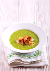 Broccoli soup with croutons on table