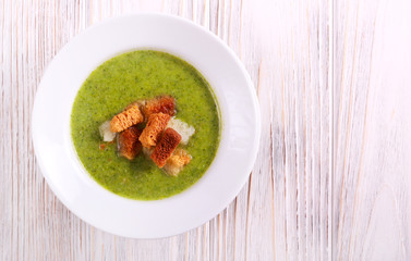 Broccoli soup with croutons on table