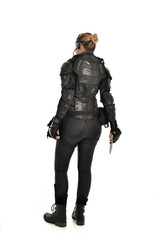 full length portrait of female  soldier wearing black  tactical armour, holding a remote knife, isolated on white studio background.