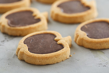 Apple shaped biscuits arranged in rows on light textured background, close-up, shallow depth of field, selective focus.