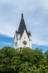 Fototapeta premium White church tower against a blue and white sky