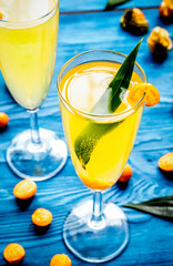 cocktail with physalis in glass on wooden background