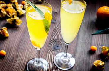 cocktail with physalis in glass on wooden background