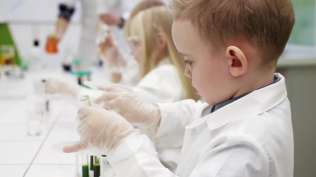 Children do an experiment in a chemistry lesson. modern education