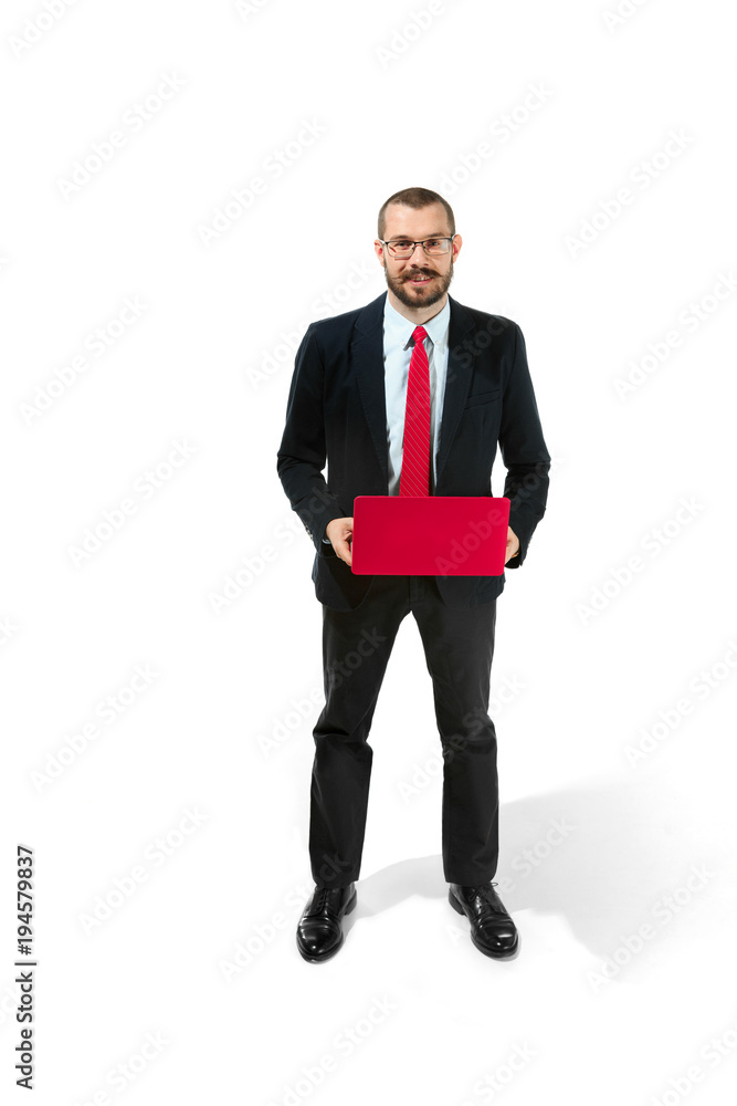 Wall mural Picture of handsome young bearded man standing over white studio background with laptop