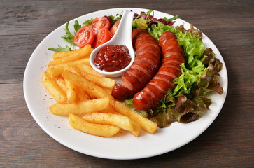 kiełbasa smażona z frytkami sałatą i pomidorem