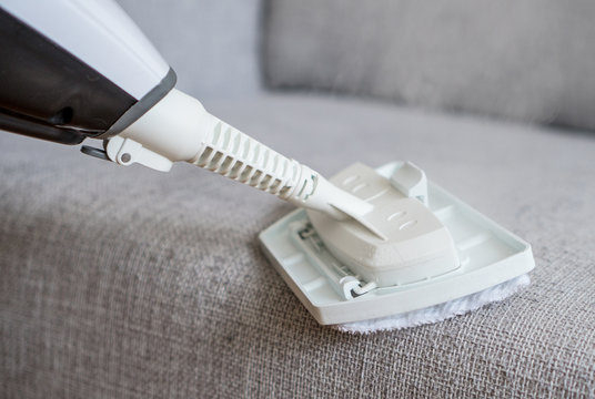 Cleaning fabric of the sofa with a steam cleaner.