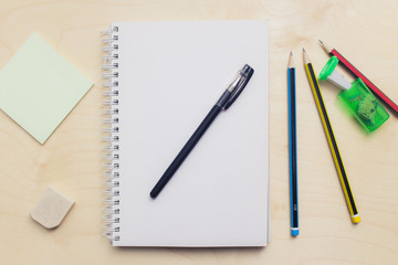 Open blank notebook on wood background with pencil.