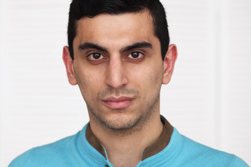 Close-up of a serious middle eastern young man's face