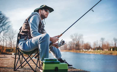 Zelfklevend Fotobehang Visser geniet van vissen op de rivier. Sport, recreatie, levensstijl © bobex73