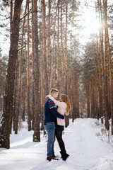 Naklejka premium full length view of happy young couple hugging in winter forest