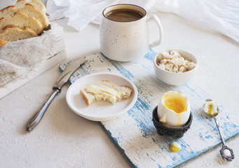 A delicious soft-boiled egg with coffee on a wooden Board. In a rustic style. Horizontal. Place for text.