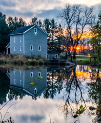 Obraz premium Mill reflected in water at sunrise