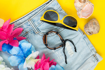 Woman summer wear, jeans shorts, sunglasses, leather bracelet, hawaiian party concept, luau party,...