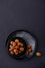 Hazelnuts in metal plate on dark background