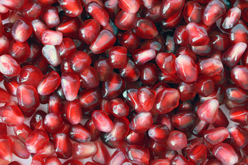 Red Background of Grain Red Grenades. Big Ripe Red Granets or Garnets. Fruits of Red Ripe Pomegranate on the White Background. Vegetarian Concept, Organic Vitamins. Organic and Benefit Garnet Fruit.