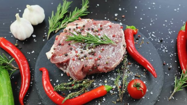 Chef cooking meat with salt spices and fresh vegetables on black wooden table. nobody apetizing tasty meal organic products ingredients recipe dish close-up modern recipe book garlic chilli pepper
