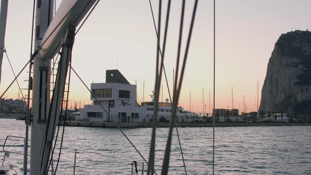View of Gibraltar and office bulding of marina Alcaidesa from baors of yacht sailing to port