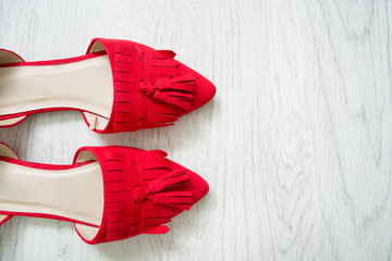 Red open shoes on a light wooden background. Top view