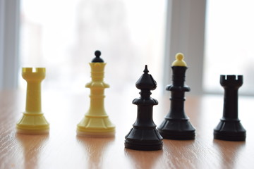 White and black chess pieces on the table.