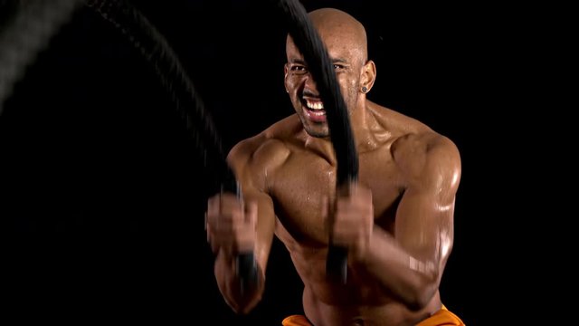 Athletic man working out with Battle Ropes. Crossfit.