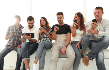 young people in casual clothes using gadgets