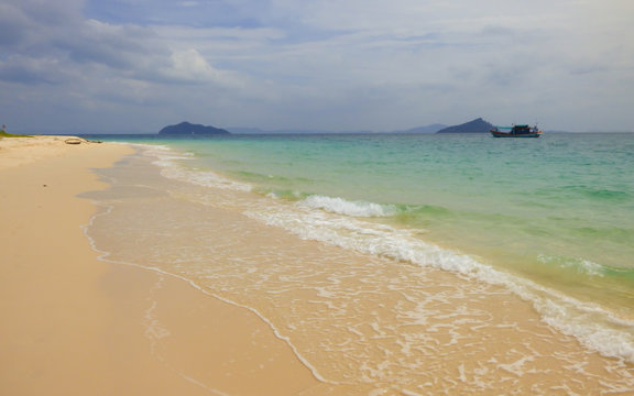 A view of beautiful "School beach" with islands and a boat in the background on Koh Bulon, Thailand (island in the Adaman sea)