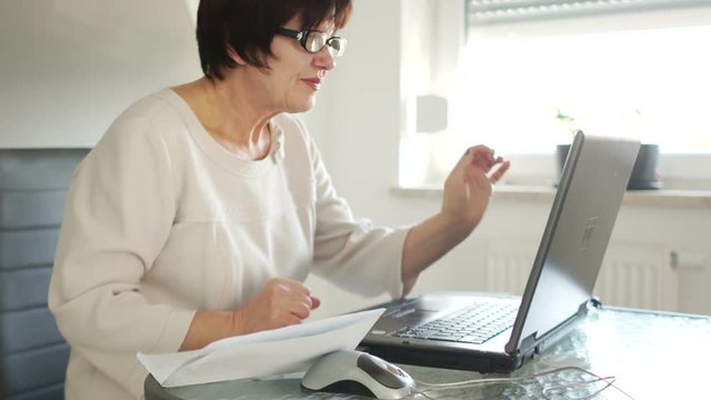 Business woman, active way of life. An active retiree talks through Skype with her partners. Telecommunications and modern technologies in the lives of older people