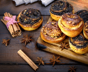 Obraz na płótnie Canvas sweet round buns with cinnamon and poppy seeds close up