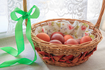 Easter eggs in the basket of wooden boards