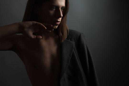 Feminine young man on a dark background. - Powered by Adobe