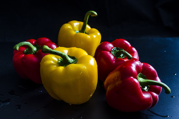 bell peppers yellow and red on black background