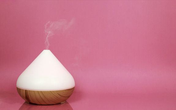Electric essential oil diffuser isolated on pink background