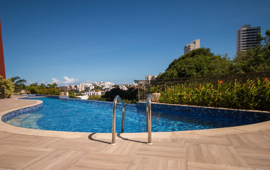 Infinity pool with trees and buildings in the background