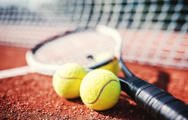 Zelfklevend Fotobehang Tennis ball with racket on the tennis court. Sport, recreation concept © bobex73