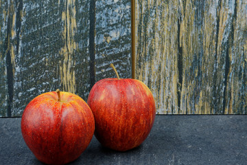 Two red apples on an old stone worktop