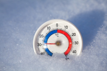 Outdoor thermometer in snow shows minus 29 Celsius degree extreme cold winter weather concept