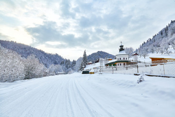 Residential building woodshed on hillside in deep snow.