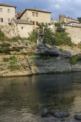 Fototapeta na wymiar MOPeople diving into Neretva river in Mostar at sunset time
