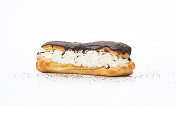 Poured with chocolate, an appetizing eclair on a white background with chocolate sprinkles