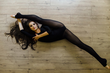 Beautiful young model ballet dancer lying inon floor. Top view.