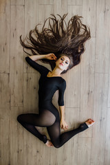 Beautiful young model ballet dancer lying inon floor. Top view.